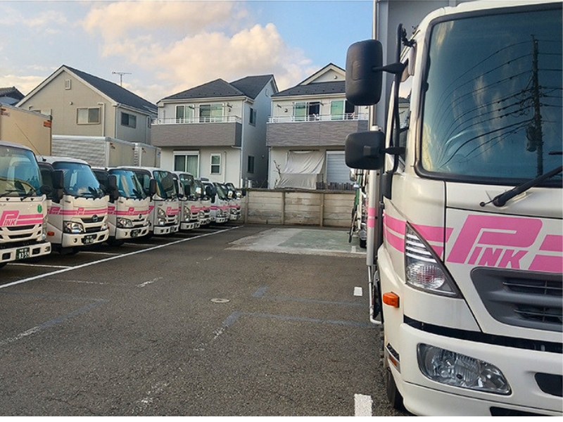 トラスト・ウィンの並んだピンクの配送車両